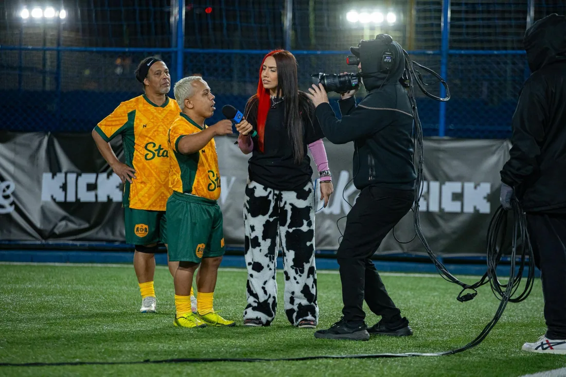Repórter entrevistando no campo com câmera